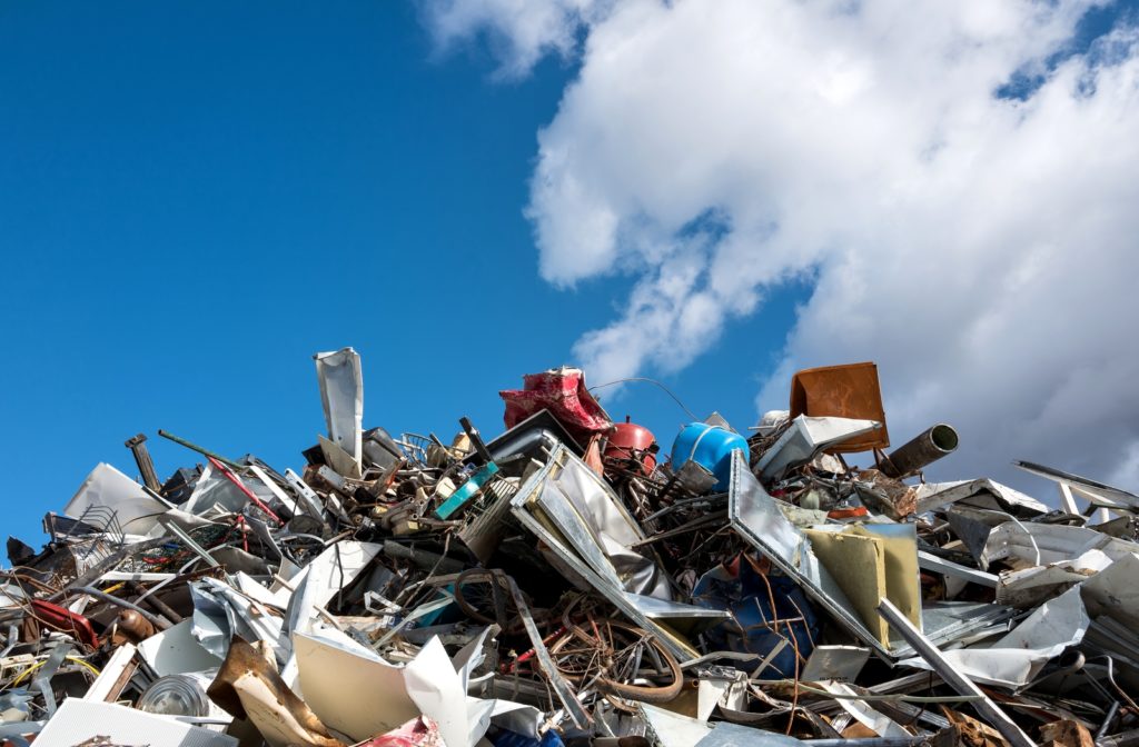 A pile of scrap metal ready to be recycled with a blue sky behind